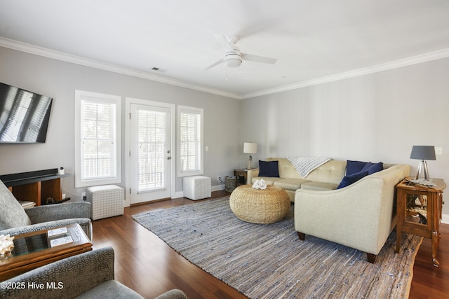 living room with dark wood-type flooring, ceiling fan, and crown molding