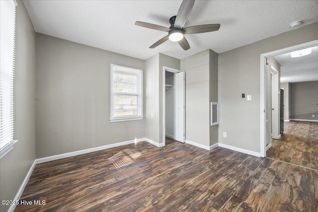 unfurnished bedroom featuring ceiling fan, dark hardwood / wood-style floors, a textured ceiling, and a closet