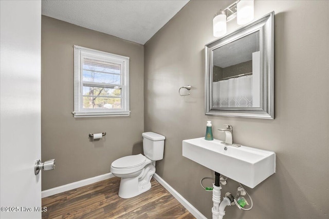 bathroom featuring hardwood / wood-style flooring, a textured ceiling, and toilet