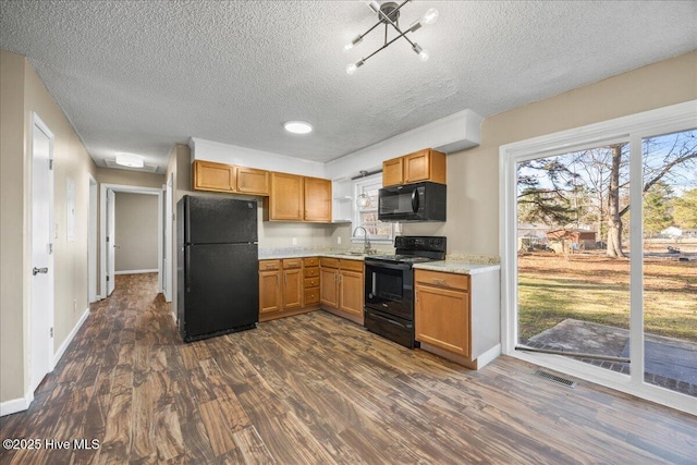 kitchen with dark hardwood / wood-style floors, sink, a textured ceiling, and black appliances