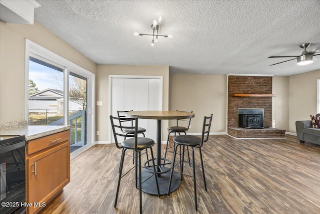 dining area with hardwood / wood-style flooring, ceiling fan, and a textured ceiling