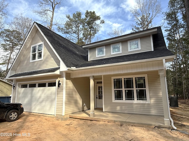 view of front of house featuring a porch, driveway, a shingled roof, and a garage