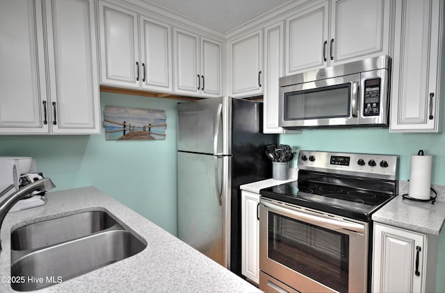 kitchen with light stone countertops, appliances with stainless steel finishes, and sink