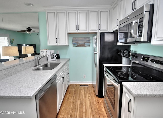 kitchen with sink, white cabinets, and appliances with stainless steel finishes