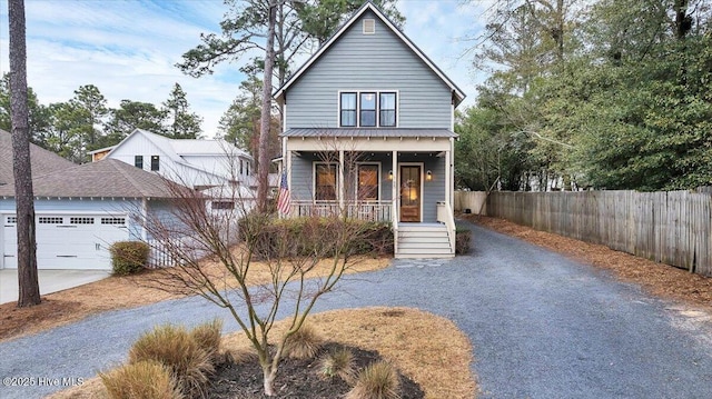 view of front of house with a porch, concrete driveway, a garage, and fence