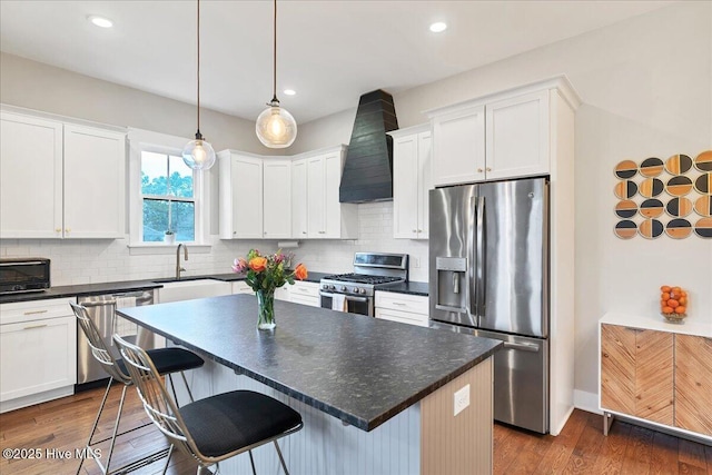 kitchen with custom range hood, dark countertops, backsplash, appliances with stainless steel finishes, and dark wood-style flooring