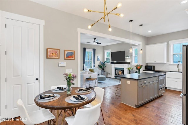 kitchen featuring hardwood / wood-style floors, a breakfast bar area, gray cabinetry, white cabinets, and dark countertops