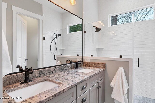 full bath featuring a sink, plenty of natural light, and a stall shower