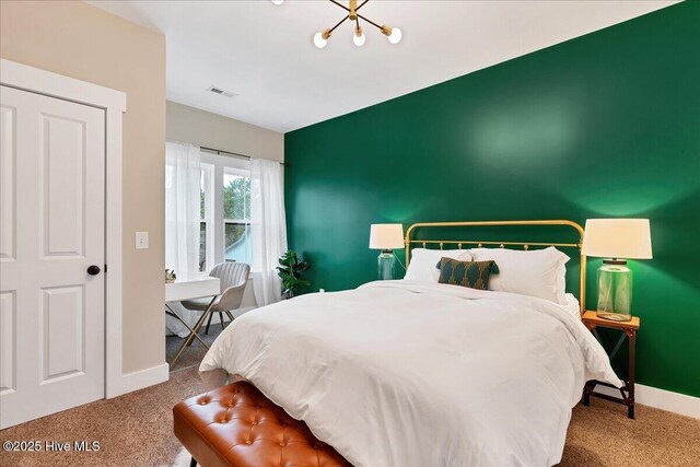 carpeted bedroom featuring visible vents, baseboards, an inviting chandelier, and an accent wall