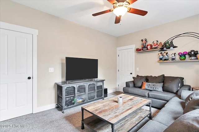 carpeted living room featuring baseboards and a ceiling fan