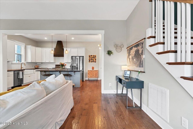 kitchen with visible vents, dark countertops, dark wood finished floors, white cabinetry, and dishwashing machine