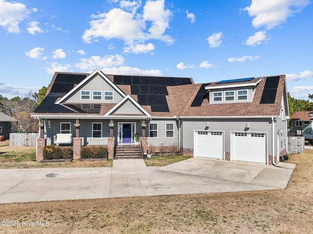 view of front facade with a porch, a front yard, and solar panels