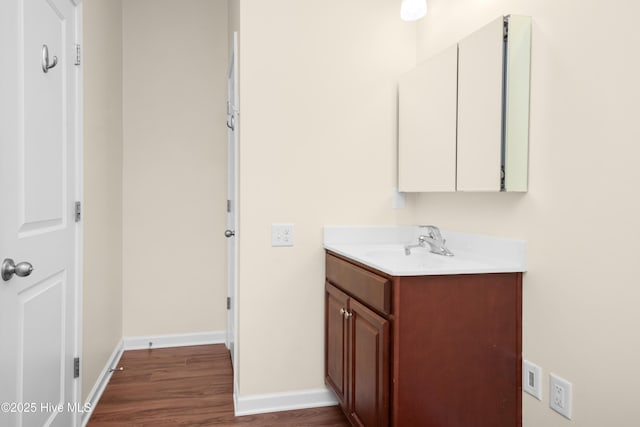 bathroom featuring baseboards, wood finished floors, and vanity