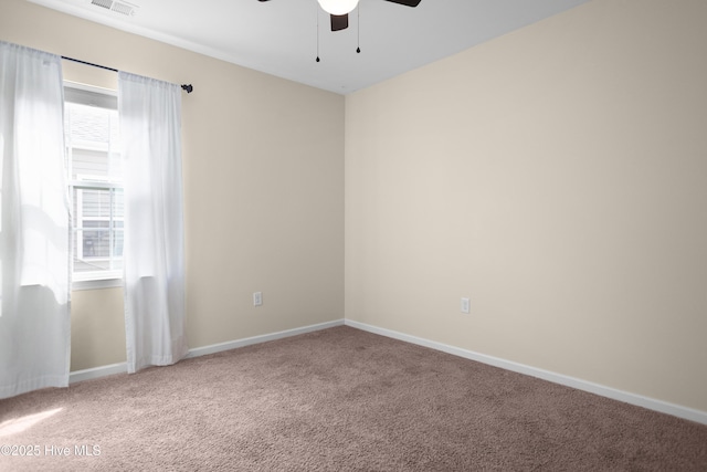 empty room featuring carpet floors, ceiling fan, visible vents, and baseboards