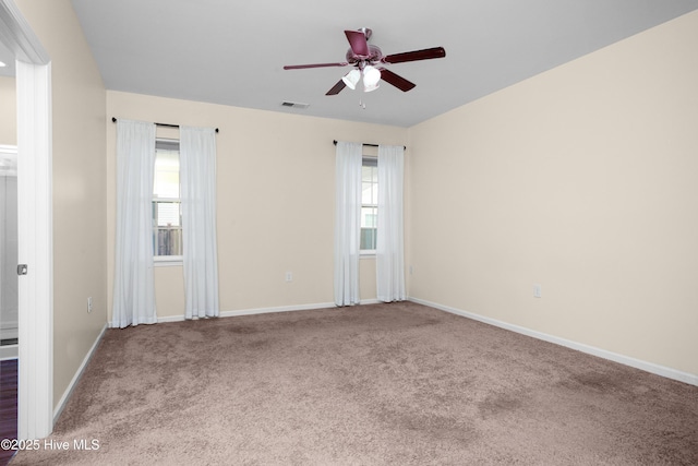 carpeted empty room featuring a ceiling fan, baseboards, and visible vents