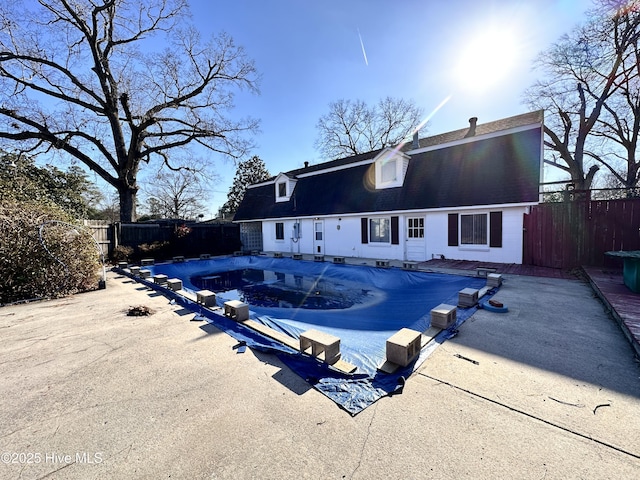 back of property with a covered pool and a patio area