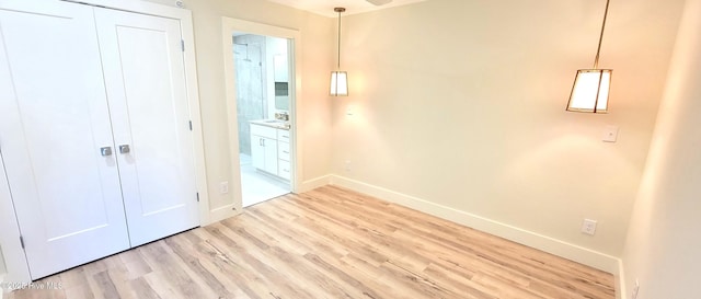 unfurnished bedroom with a closet and light hardwood / wood-style flooring