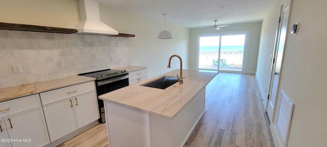 kitchen with sink, a kitchen island with sink, white cabinetry, custom range hood, and stainless steel electric stove