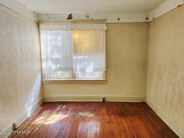 unfurnished room with dark hardwood / wood-style flooring