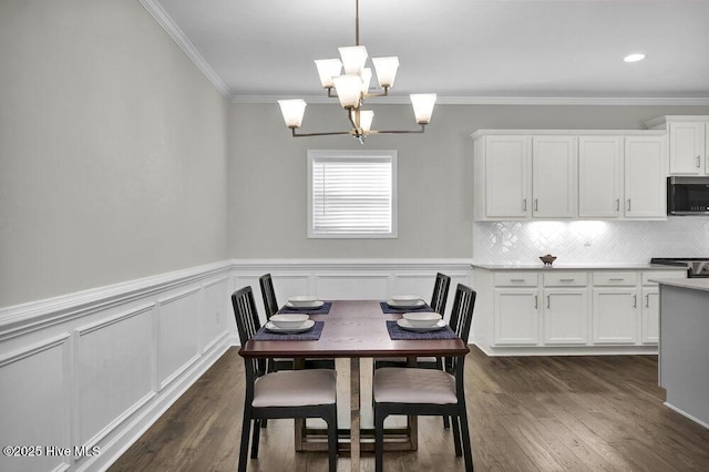 dining space featuring crown molding, dark wood-type flooring, and an inviting chandelier