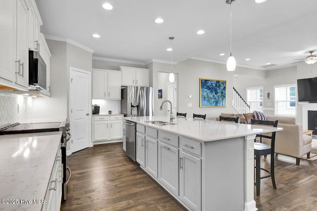 kitchen featuring pendant lighting, sink, white cabinets, and appliances with stainless steel finishes