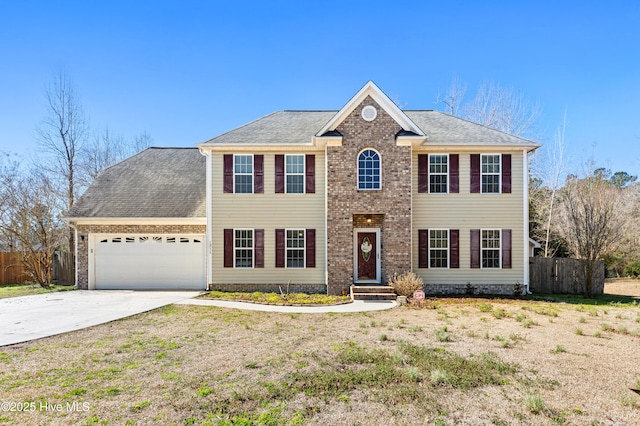 colonial house featuring a garage, driveway, fence, and brick siding