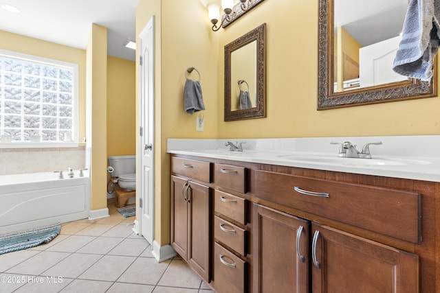 full bathroom with double vanity, toilet, a sink, tile patterned flooring, and a bath