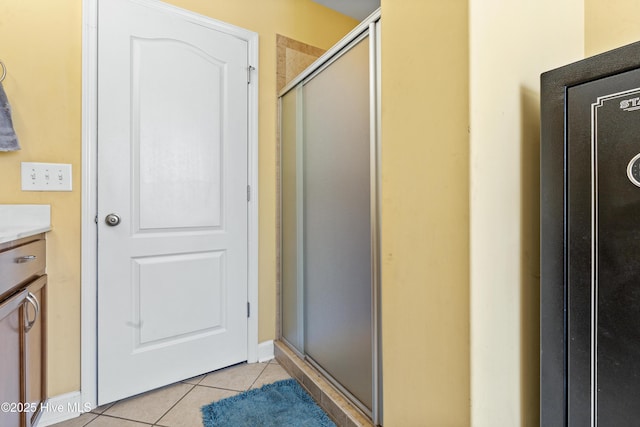 bathroom with a stall shower, vanity, and tile patterned floors