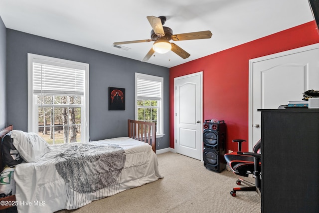 carpeted bedroom with baseboards, visible vents, and a ceiling fan