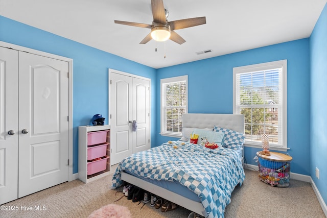 bedroom featuring carpet floors, baseboards, multiple windows, and visible vents