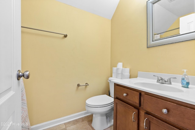 bathroom featuring baseboards, vanity, toilet, and tile patterned floors