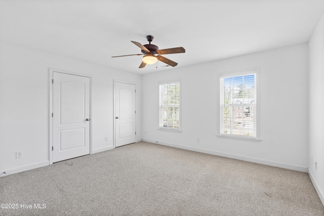 unfurnished bedroom featuring ceiling fan, carpet floors, two closets, and baseboards