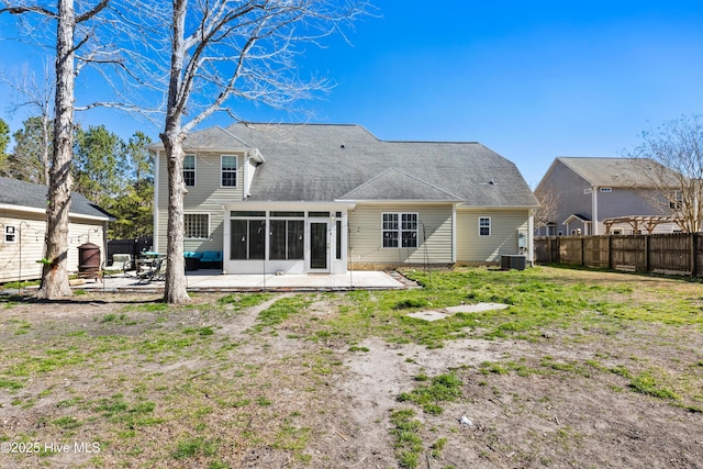 rear view of property with central AC unit, a sunroom, fence, a yard, and a patio area