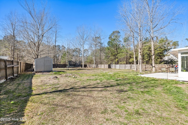 view of yard featuring a fenced backyard, a storage shed, an outdoor structure, a trampoline, and a patio area