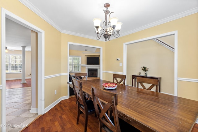 dining space with a fireplace, ornate columns, ornamental molding, baseboards, and tile patterned floors