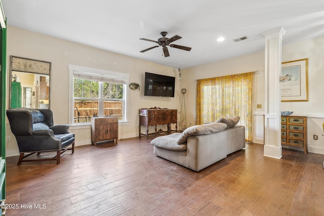 living room featuring hardwood / wood-style flooring, ceiling fan, and decorative columns