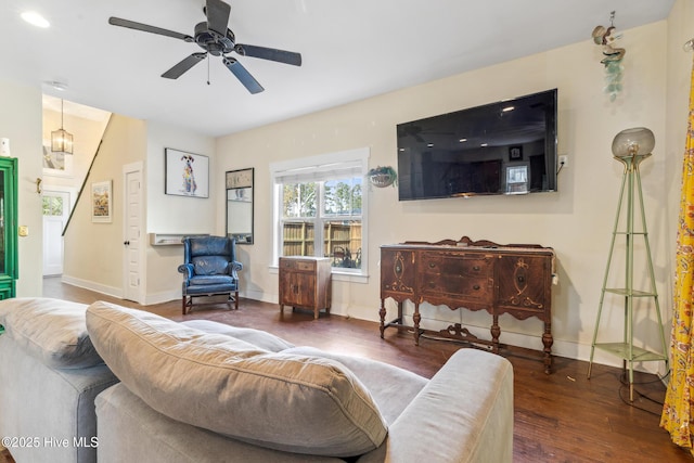 living room featuring ceiling fan and dark hardwood / wood-style flooring