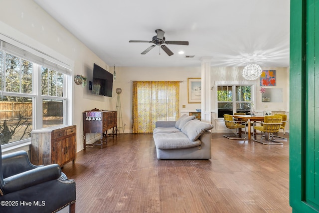 living room with ornate columns, hardwood / wood-style floors, and ceiling fan