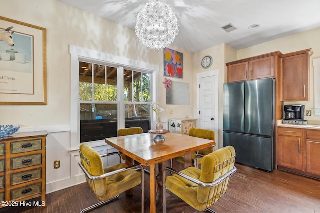 dining space featuring dark hardwood / wood-style floors and a chandelier