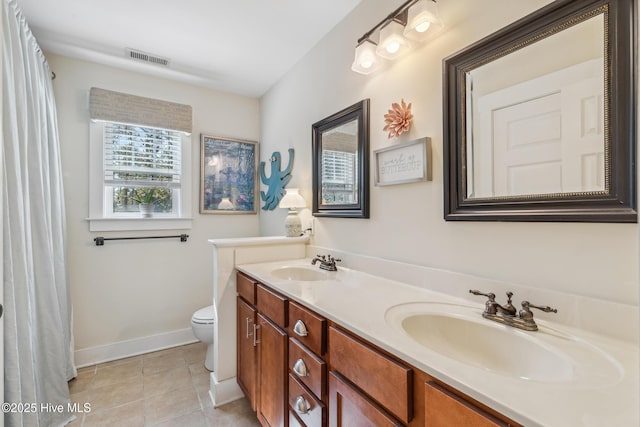 bathroom with tile patterned flooring, vanity, and toilet