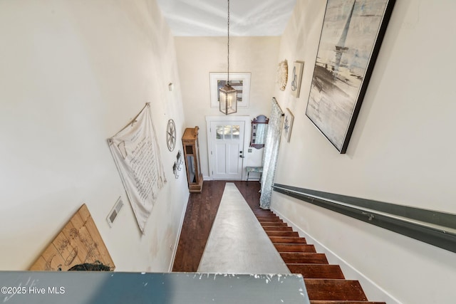 stairs featuring hardwood / wood-style floors and a towering ceiling