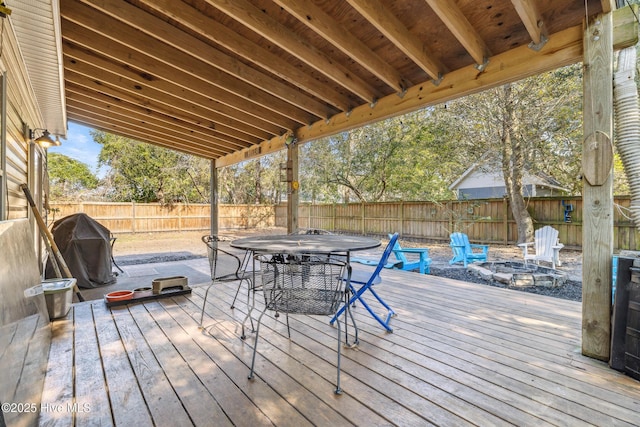 wooden terrace with a grill and an outdoor fire pit