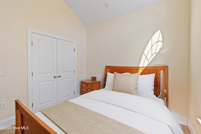 bedroom with lofted ceiling and a closet