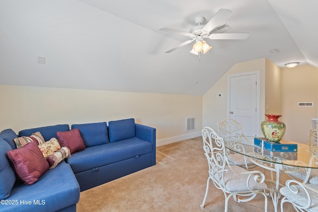 carpeted living room with ceiling fan and vaulted ceiling