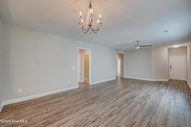 spare room with hardwood / wood-style flooring and ceiling fan with notable chandelier