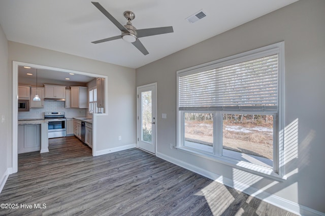 kitchen featuring sink, hanging light fixtures, dark hardwood / wood-style flooring, stainless steel appliances, and decorative backsplash