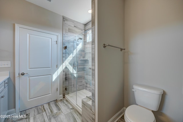 bathroom featuring vanity, an enclosed shower, and toilet