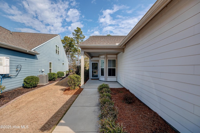 view of exterior entry featuring a patio and central AC