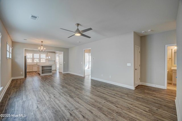 unfurnished living room featuring dark hardwood / wood-style floors and ceiling fan with notable chandelier