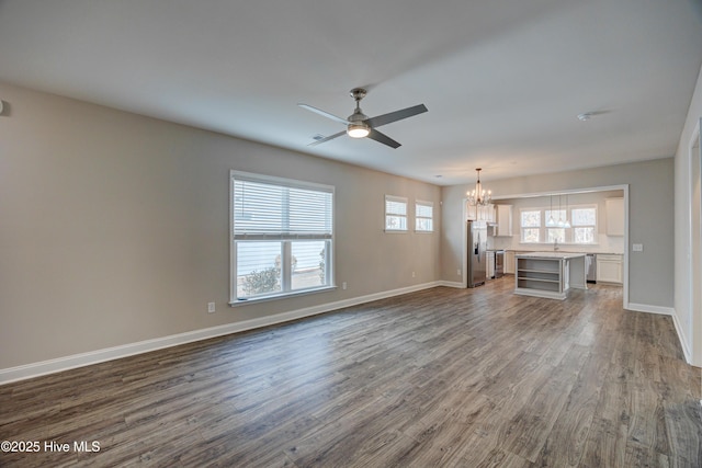 unfurnished living room with wood-type flooring and ceiling fan with notable chandelier